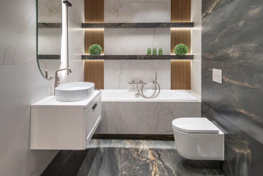 Drewnopodobne dekory połączone z imitacją szarego i białego marmuru w łazience w stylu SPA.