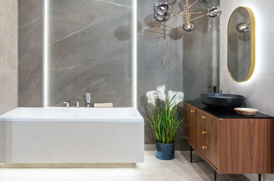 Stylowa łazienka z akcentami retro z wanną zabudowaną beżowymi płytkami imitującymi kamień.