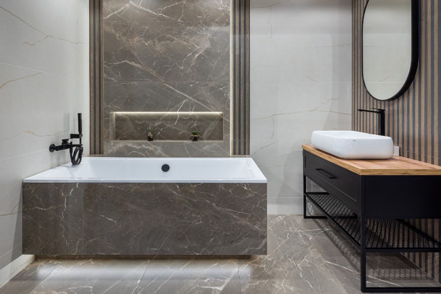 Wanna zabudowana płytkami imitującymi marmur.